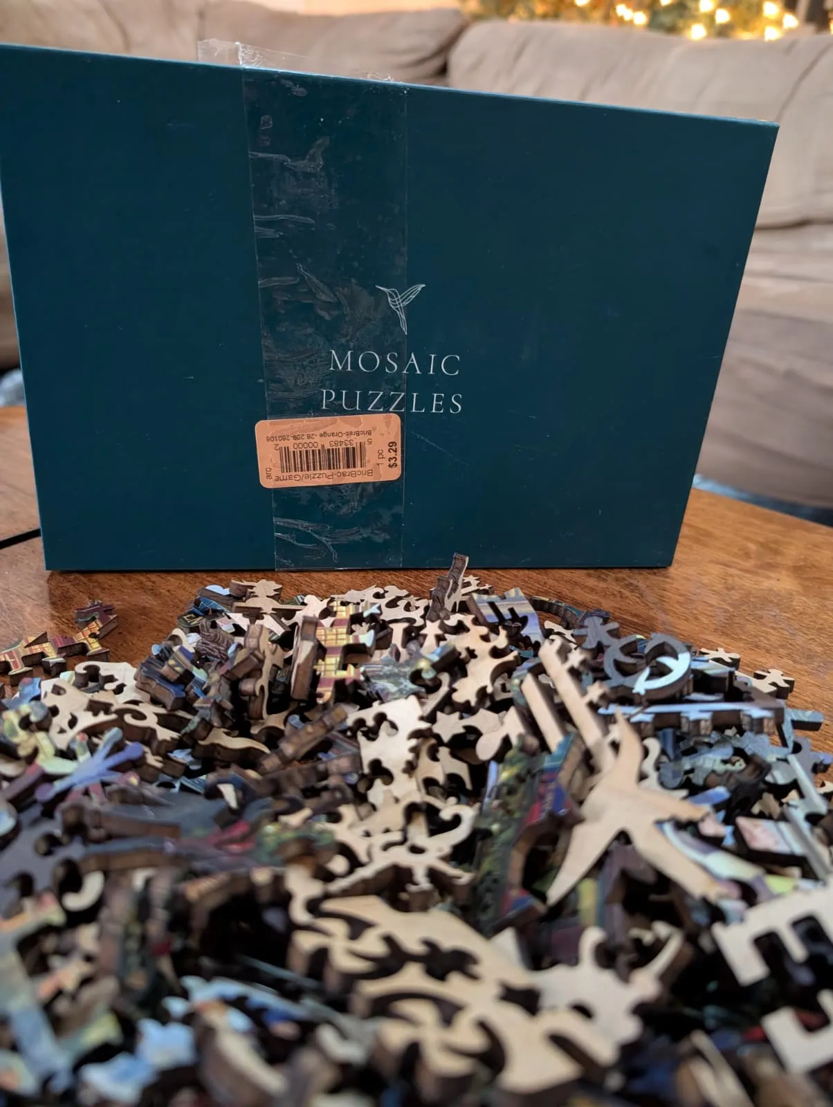 The Mosaic Puzzles box with a pile of wooden pieces dumped out in front of it